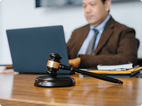 Judge's gavel on desk near laptop.