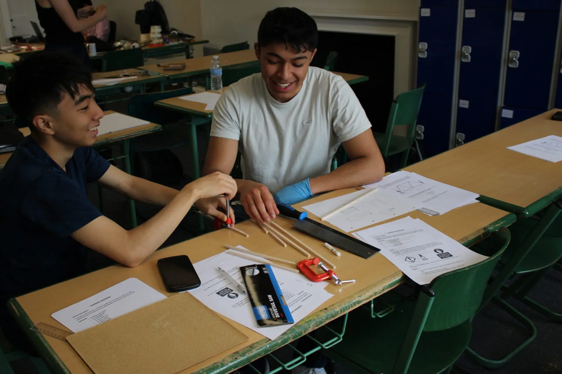 Two students building a model in class.